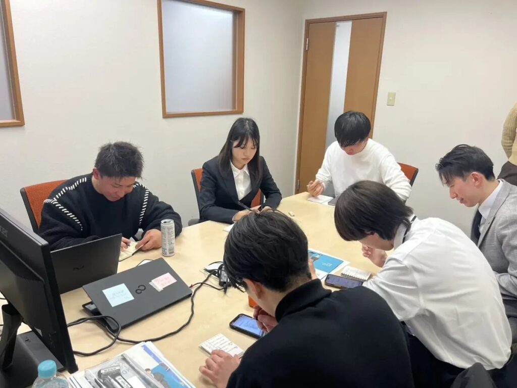 オリエンテーションでNASAゲームに取り組む新入社員と先輩社員